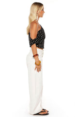 Model wearing a crisp white off-shoulder crop top and white wide-leg jeans perfect for a fresh Spring look