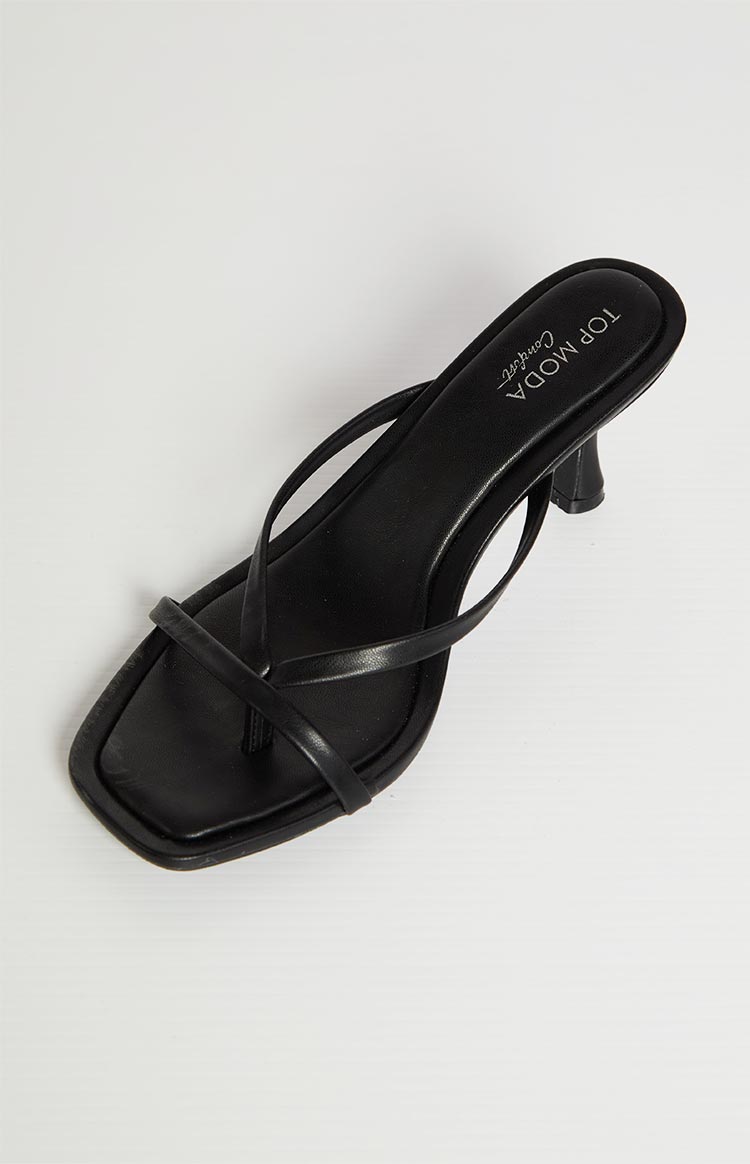 A single black heeled sandal with thin straps is shown on a light background. The sandal has a square toe and a small