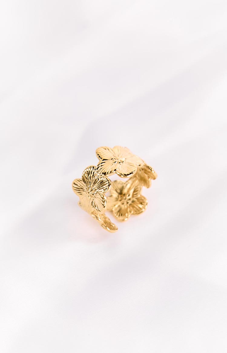 A shiny gold ring designed with multiple interconnected flower shapes.