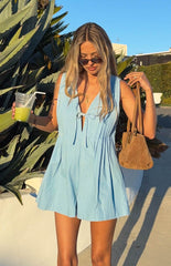 model wearing a flowy light blue playsuit with front tie detail