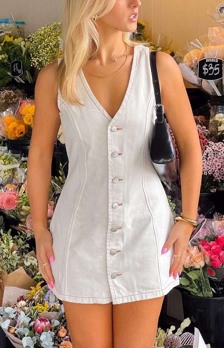 A versatile white wash denim mini dress- designed with a V-neckline and a full-length button-front closure- accented with contrasting stitching- suitable for a casual outing.