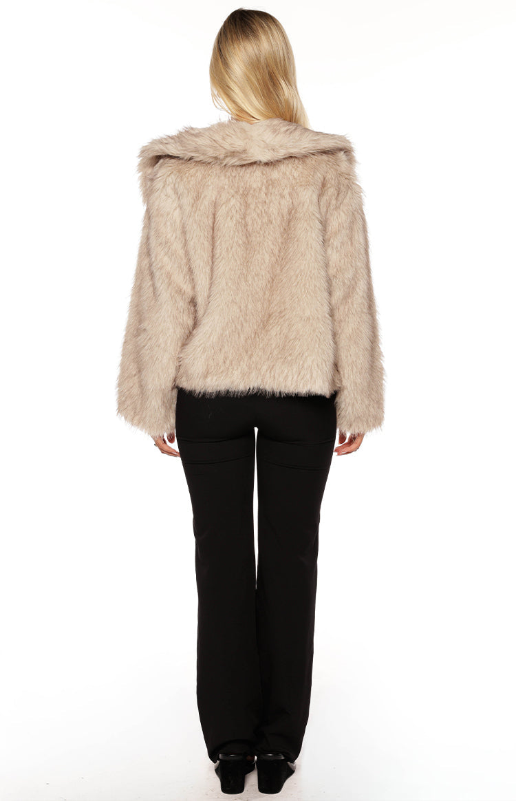 Woman wearing a luxurious sand faux fur jacket with wide leg jeans a glamorous choice for an Autumn event