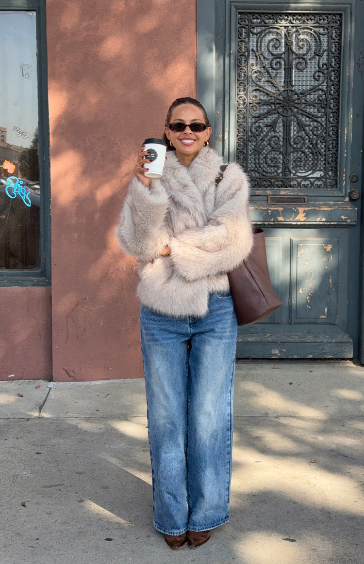 Smiling girl in a cozy beige faux fur coat a stylish and warm layer for a cool Fall evening