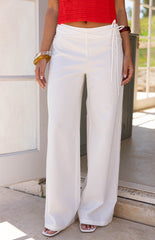 Model wears the Jacq White Wide Leg Pants featuring a flattering mid rise waist and tie detail. These flowy trousers are perfect for resort wear or a summer vacation.