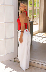 Model wears the Jacq White Wide Leg Pants featuring a flattering mid rise waist and tie detail. These flowy trousers are perfect for resort wear or a summer vacation.