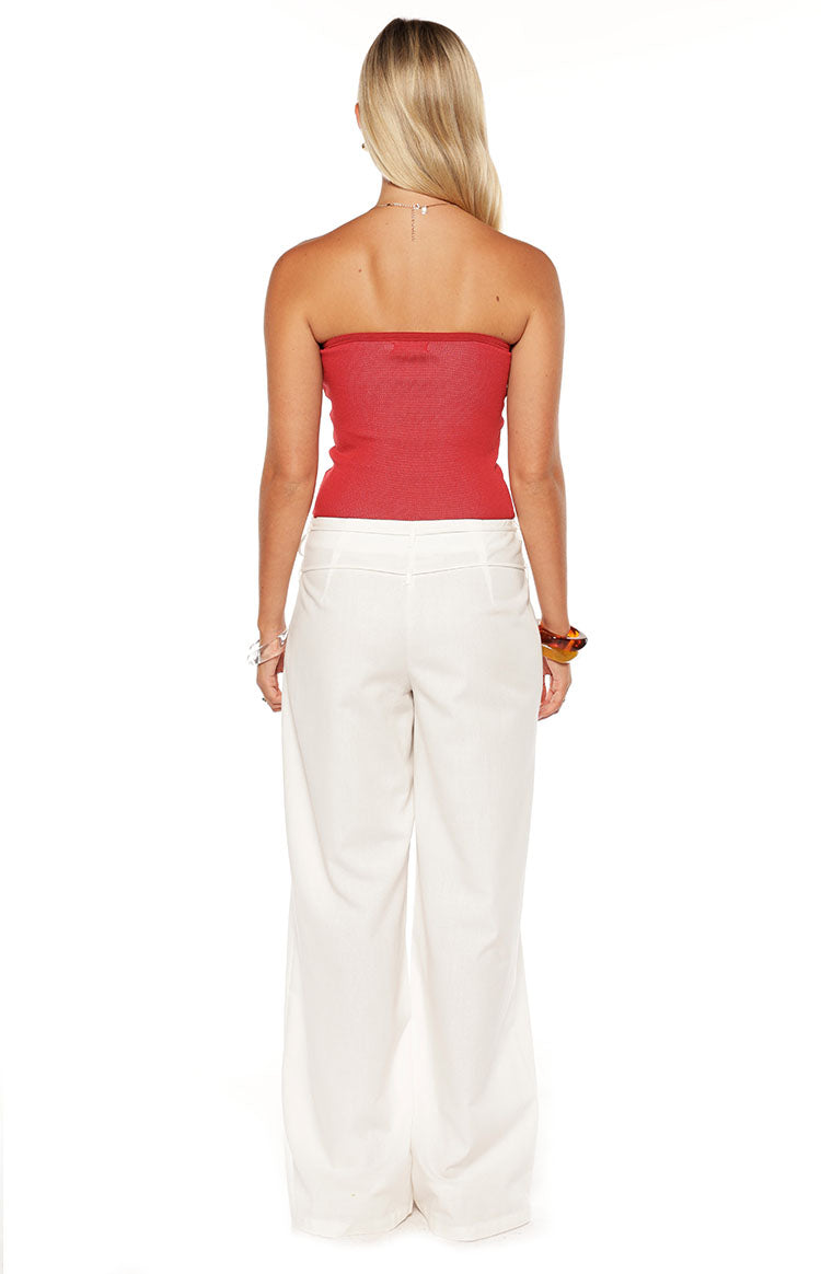 Model wears the Jacq White Wide Leg Pants featuring a flattering mid rise waist and tie detail. These flowy trousers are perfect for resort wear or a summer vacation.