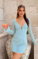 Baby blue long sleeve mini dress with sheer sleeves and tie at bust styled on brunette model.