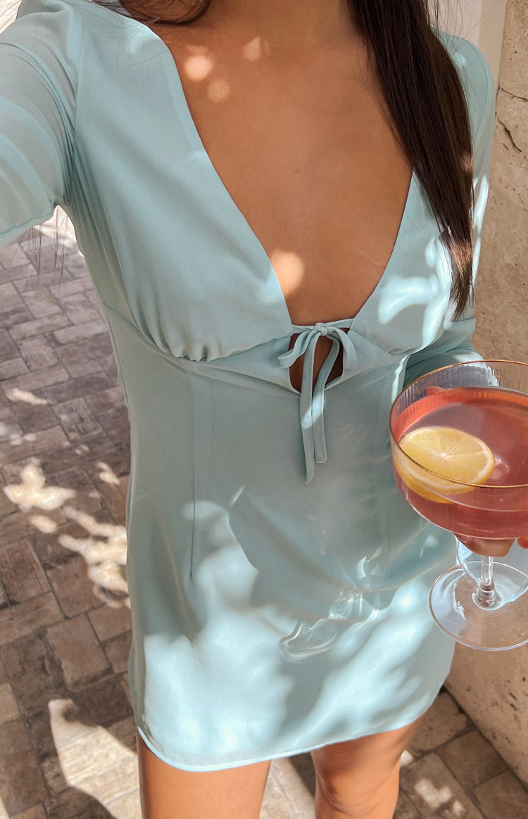 Light blue mini dress with long sheer sleeves, deep neckline and tie between bust. 