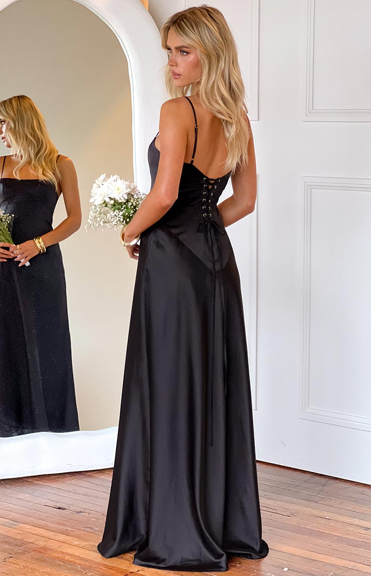 blonde model wearing a black satin formal gown with a lace up corset back detail