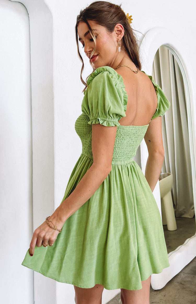 Belle Lucia posed in green flowy mini dress.