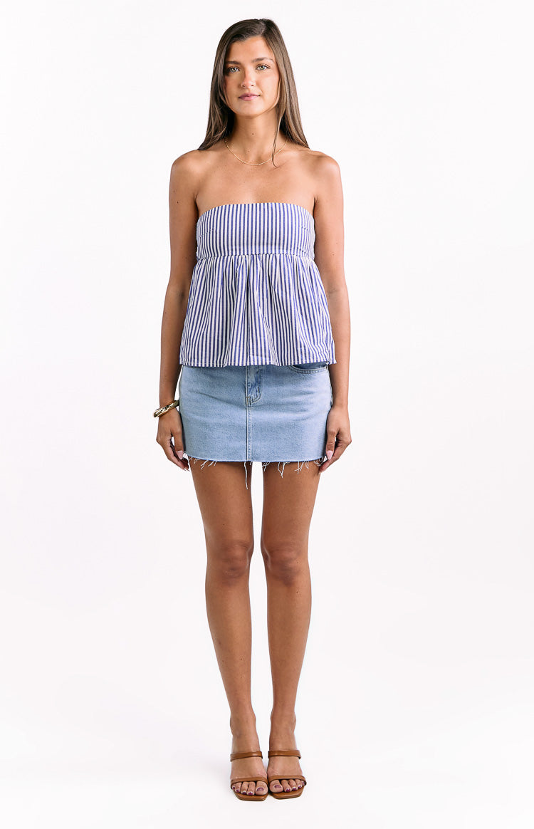 featuring a smocked bodice and a peplum hem. It is paired with white bottoms. This top is suitable for a casual summer day.