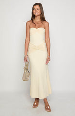 Blonde model wearing a strapless cream mesh maxi dress with ruched details through the bodice
