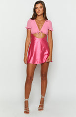 pink cap sleeve mini dress with adjustable tie front on brunette model\