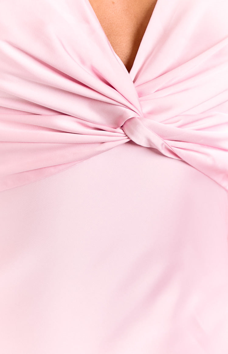 Model wears a light pink v-neck maxi dress. This romantic formal dress features a gathered bust and a flowy A-line skirt. A beautiful option for a wedding guest or special occasion.