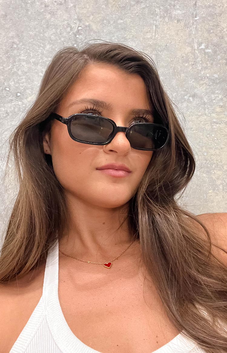 girl wearing black rectangle frame sunglasses with smokey black lenses