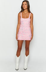 pink sparkly sequin mini dress with thick straps and flower detailing on brunette model