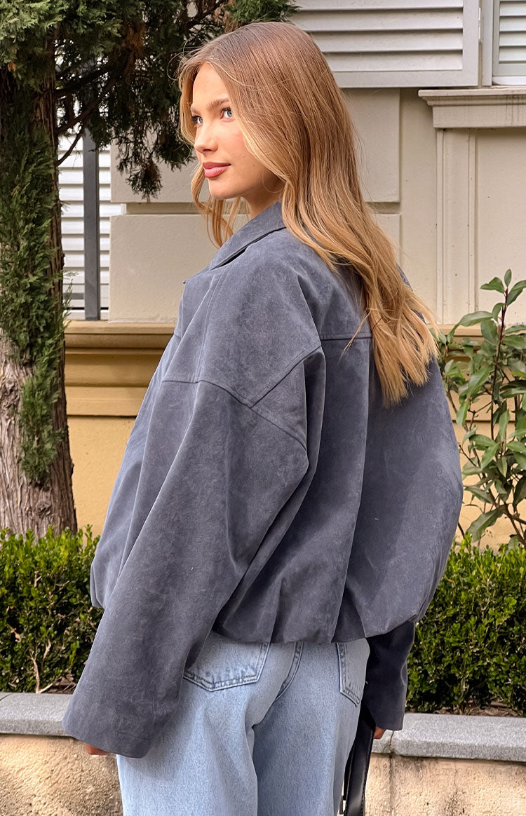 Girl in an oversized grey bomber jacket made from suedette fabric for a casual outerwear look.