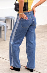 Back view of mid-wash denim low-rise wide-leg jeans- featuring a distinct lighter wash vertical stripe along the outer seams- offering a unique casual style.