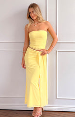 blonde model wearing a yellow mesh two piece set with gold jewellery and nude heels