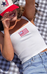 Model wearing a white sleeveless tank top with a red and blue patch graphic on the front