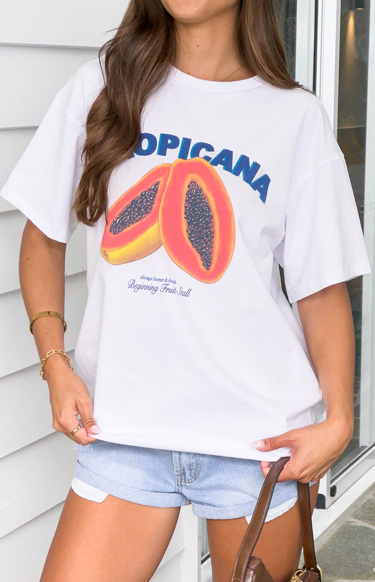 Model wearing a white oversized t shirt with a tropical fruit graphic print