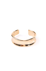 A gold cuff bangle with a unique wavy design. This eye-catching accessory can elevate a date night look or a casual outfit. A fashionable gift for a birthday or special occasion.