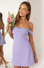 A person wearing a lavender off-the-shoulder mini dress with a wrapped or ruched bodice.